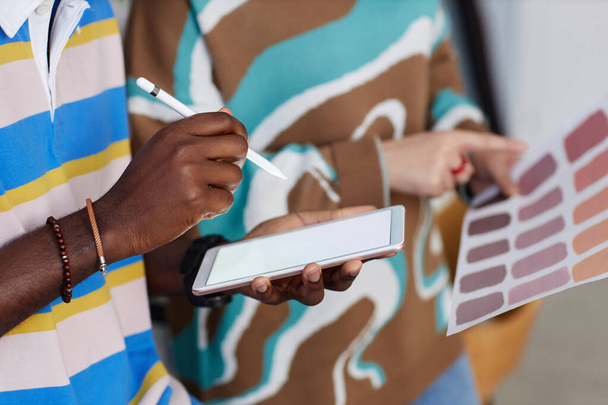 Meslektaşıyla paleti tartışırken dijital tablete not alan tasarımcının yakın çekimi - Fotoğraf, Görsel