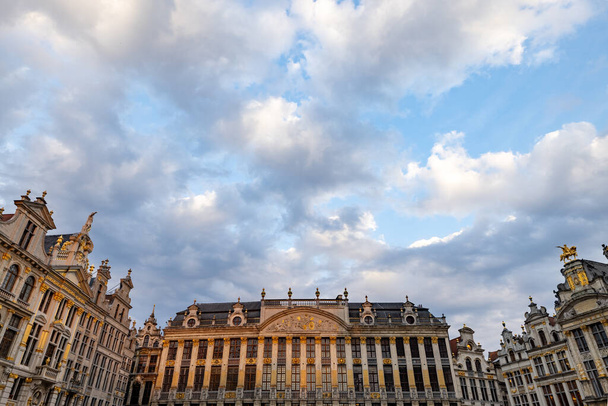 Bruksela, Belgia, 23 czerwca 2023 r., Malowniczy zespół gildii Grand Places pod urzekającym niebem, gdzie zawiłe fasady całuje miękki blask zanikającego słońca. Chmury - Zdjęcie, obraz