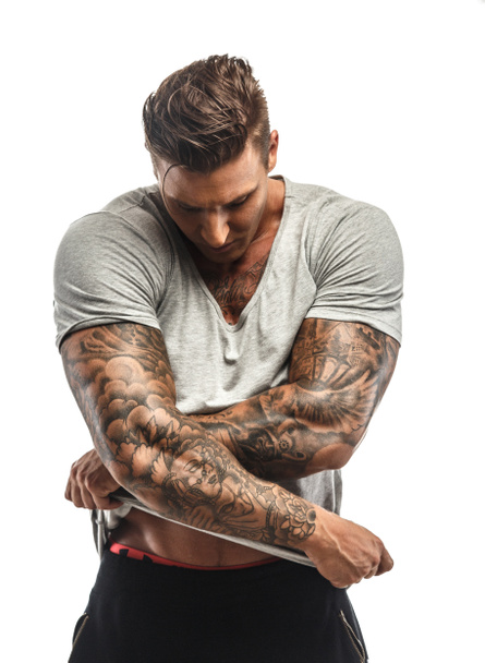 Lihaksikas kaveri, jolla on tatuoitu vartalo
 - Valokuva, kuva