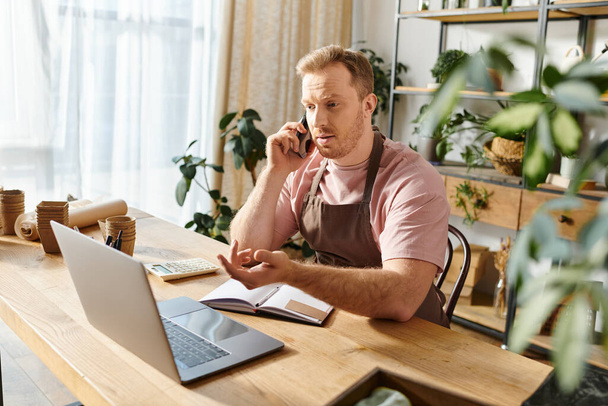 Muž s laptopem, zaměřený na svou práci v květinářství, ztělesňuje ducha podnikání a oddanosti. - Fotografie, Obrázek