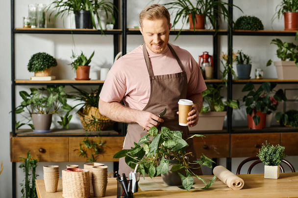 Un hombre carismático en un delantal disfruta de una taza de café en su tienda de plantas, encarnando la esencia del emprendimiento. - Foto, imagen