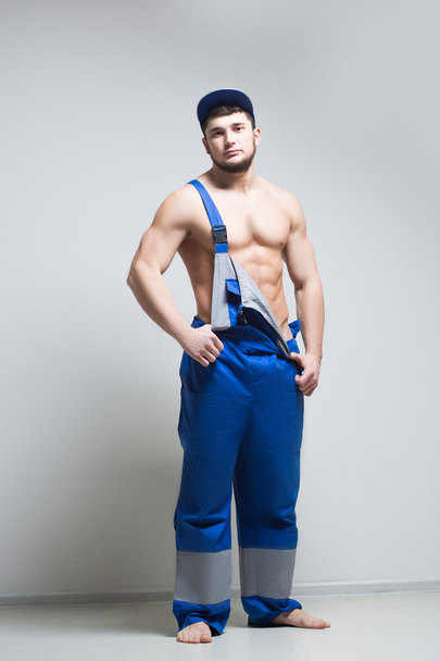 muscular construction worker in overalls - Foto, Bild