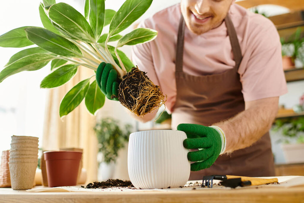 Un hombre acuna amorosamente una planta en maceta en sus manos en una tienda de plantas, mostrando su pasión por la naturaleza y el cultivo. - Foto, imagen