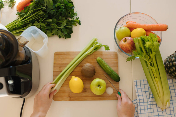 Draufsicht auf verschiedene Biolebensmittel für Saft. Gemüse und Obst auf einem Holztisch. Saftpresse. Hochwertiges Foto - Foto, Bild