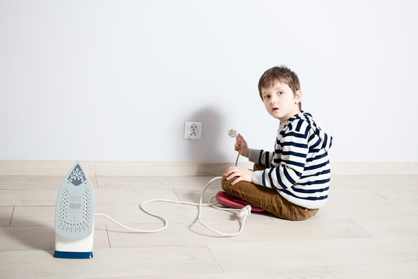 Αγόρι που παίζουν επικίνδυνα με ηλεκτρικό καλώδιο - Φωτογραφία, εικόνα