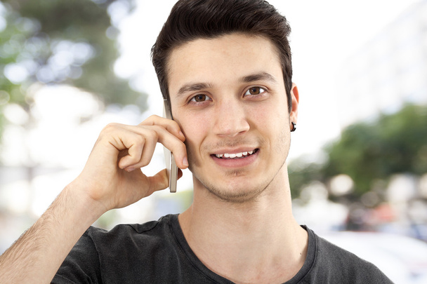 Young man talking mobile phone on street - Фото, зображення