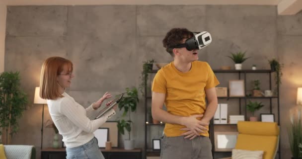 мужчина молодая пара мужчина дома пользоваться виртуальной реальности VR гарнитуры - Кадры, видео