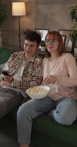 para kaukaski mężczyzna i kobieta siedzieć w domu na kanapie łóżko oglądać TV film - Materiał filmowy, wideo