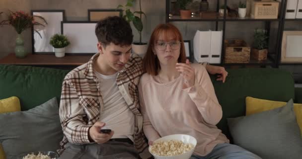 Pár kavkazský muž a žena sedět doma na pohovce postel sledovat TV film - Záběry, video