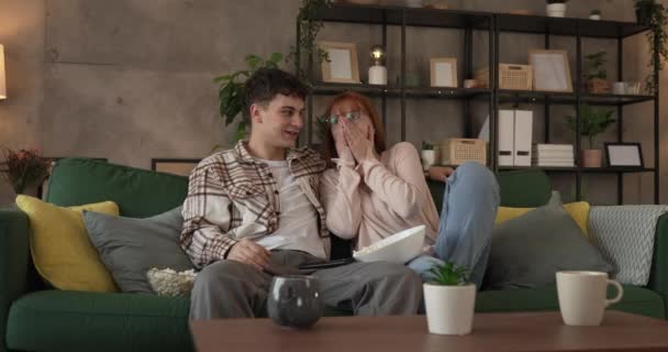 para kaukaski mężczyzna i kobieta siedzieć w domu na kanapie łóżko oglądać TV film - Materiał filmowy, wideo