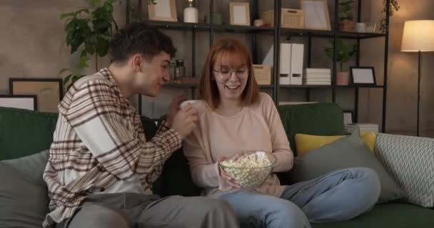 Coppia caucasico uomo e donna sedersi a casa sul divano letto guardare il film tv - Filmati, video