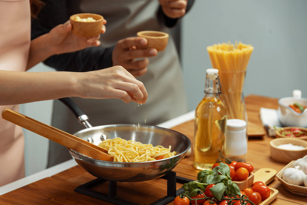 Lähikuva käsi pari kokki vaikuttajia ruoanlaitto spagetti sekoita ainesosa ottaen paistinpannu, laittamalla mausteita ja maukasta kastiketta tehdä hyvää makua, Käsite esittää kotitekoista ruokaa. Asettelu. - Valokuva, kuva