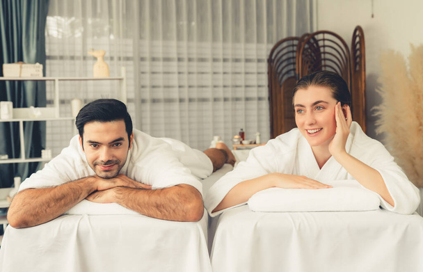 Кавказька пара клієнтів насолоджується розслабляючим антистресовим спа-масажем і бродить з дозвіллям краси шкіри відпочинку в денному світлому навколишньому салоні спа в розкішному курорті або готелі. Тихіше - Фото, зображення