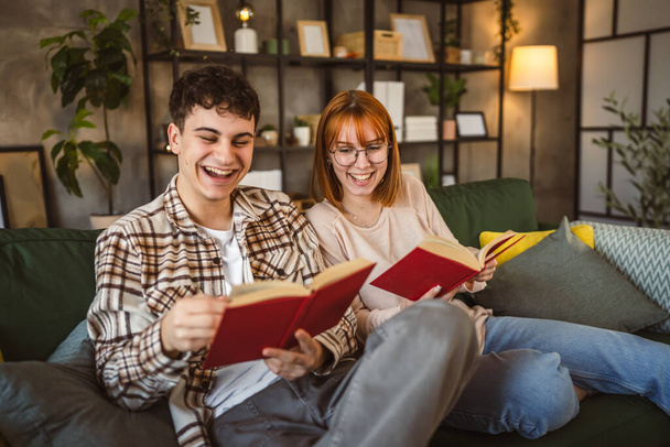 hombre y mujer caucásico pareja de adultos leer libros en casa en sofá cama - Foto, Imagen