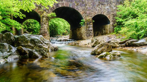 Imagen de larga exposición del río West Fork Pigeon bajo el puente Tripple Arch cerca de Maggie Valley, Carolina del Norte. - Foto, imagen