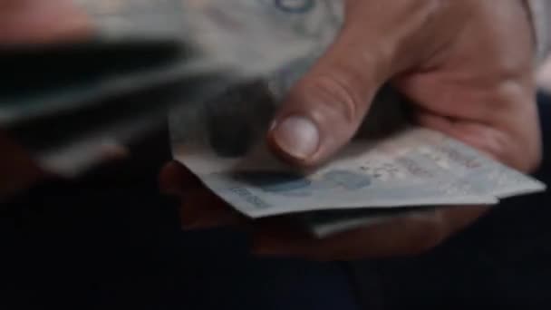 Rio de Janeiro (RJ), Brazília - 2024 / 10 / 03 - Illusztratív kép a pénzmosásról, amint a ruhaszárítón lógnak az igazi bankjegyek. Érméket mosnak, és egy ember keze számolja a tiltott pénzt. R $100 Reais bankjegyek. - Felvétel, videó