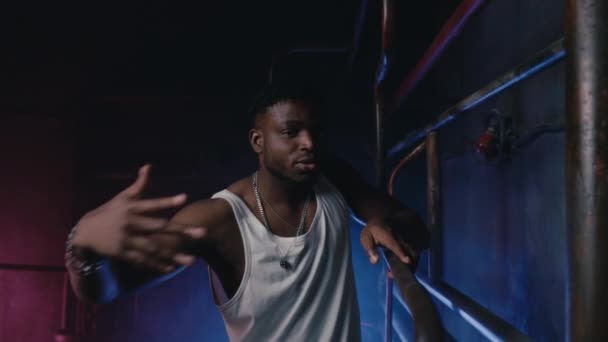 Der muskulöse Rapper tanzt im Neonlicht eines coolen Nachtclubs. Moderne Hip-Hop-Tänzerin führt urbanen Freestyle-Tanz auf - Filmmaterial, Video