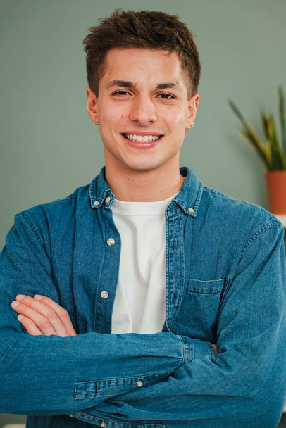 Ritratto verticale individuale di un giovane ragazzo caucasico adulto che sorride e guarda la macchina fotografica con espressione amichevole. Headshot di un vero studente adolescente con i denti bianchi che fissano davanti a casa - Foto, immagini