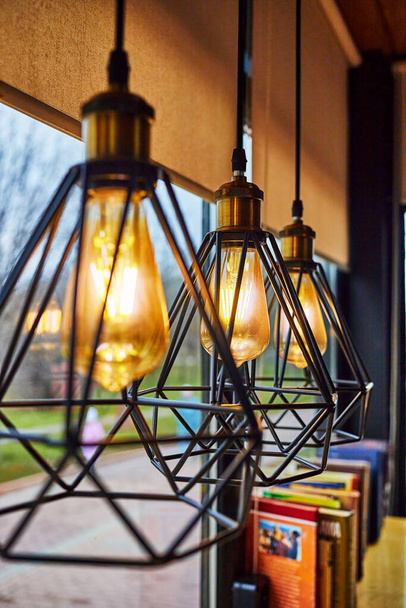 Dekorative moderne LED-Lampen im Retro-Edison-Lampenstil in einem Straßencafé - Foto, Bild