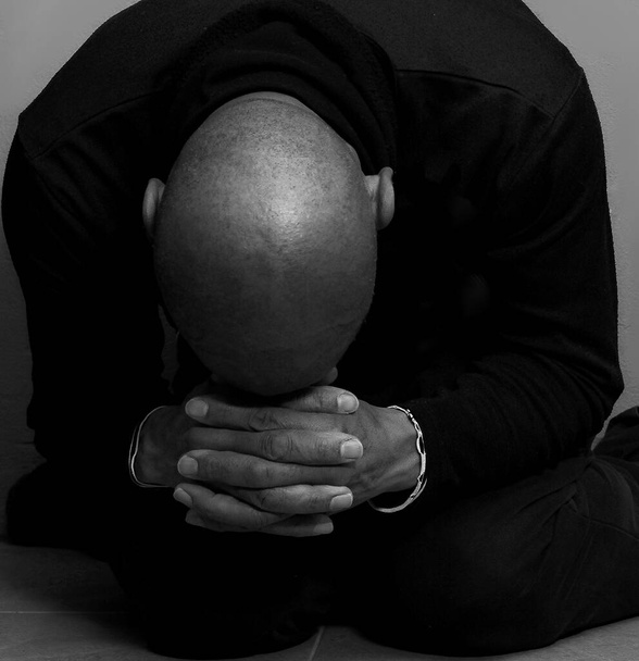 Homme caribéen priant Dieu avec les mains ensemble, photo studio noir et blanc - Photo, image