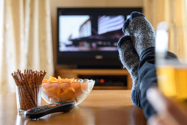 Televisión, TV viendo (película) con los pies en la mesa y enorme amou
 - Foto, Imagen