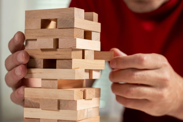 Planificación, riesgo y estrategia en negocios, hombres de negocios e ingenieros de apuestas colocando bloques de madera en una torre
. - Foto, imagen