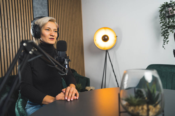 Egy női rádióműsorvezető élő podcastben beszél, egy stúdióban dolgozik. Kiváló minőségű fénykép - Fotó, kép
