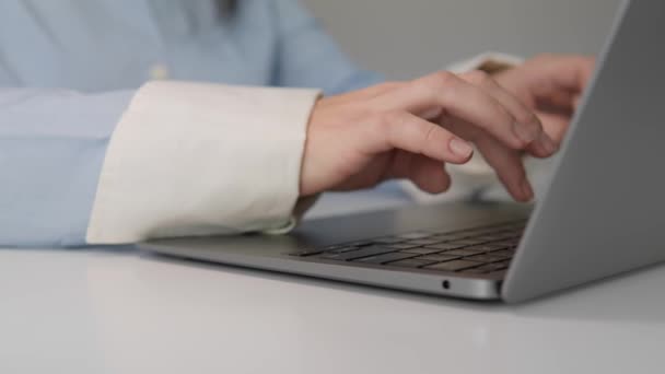 テーブルのノートパソコンのキーボードにタイピングする女性の手のクローズアップ. 女性はオンラインでコンピュータで働き,研究しています. オフィスまたは自宅で電子文書を使用する. 高品質4Kについて - 映像、動画