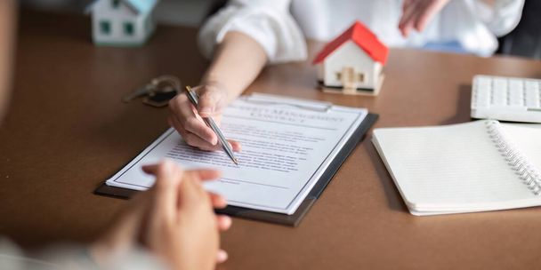 Ügyfél találkozó és tárgyalás az ingatlanügynökökkel a bérbeadásról, a lakásvásárlásról, az ingatlanügynöki tárgyalásról, a lakásvásárlási szerződés feltételeiről és a szerződés aláírására való felkérésről. - Fotó, kép
