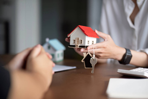 Agente de bienes raíces entregar la propiedad o nuevas llaves del hogar a un cliente
. - Foto, Imagen