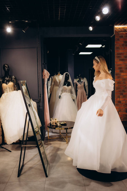 Красивая невеста примеряет свадебное платье в магазине - Фото, изображение