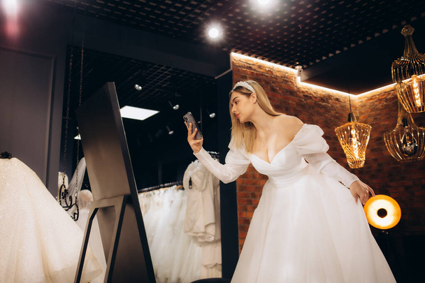 belle mariée essayant sur une robe de mariée - Photo, image