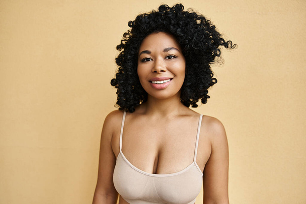 A diverse woman in pastel bra poses gracefully - Foto, afbeelding
