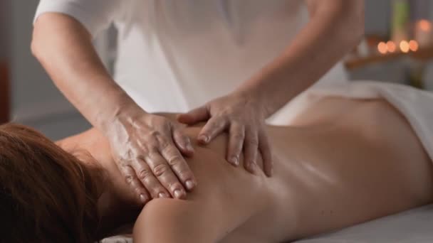 Uwolnij napięcie i przywróć wewnętrzną harmonię poprzez masaż mający na celu ukojenie energii seksualnej. Masaż ramion i łopatek z bliska. Kobieta odpoczywa i relaksuje się na masażu - Materiał filmowy, wideo