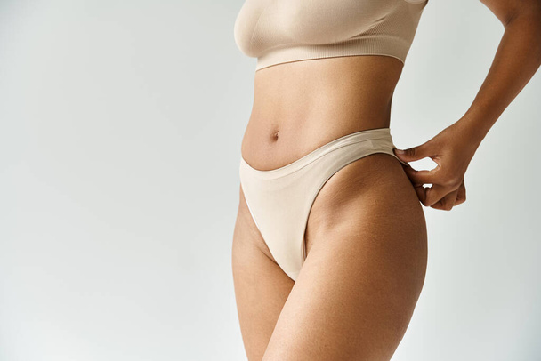 A woman in cozy tan bikini top and panties poses gracefully. - Photo, Image