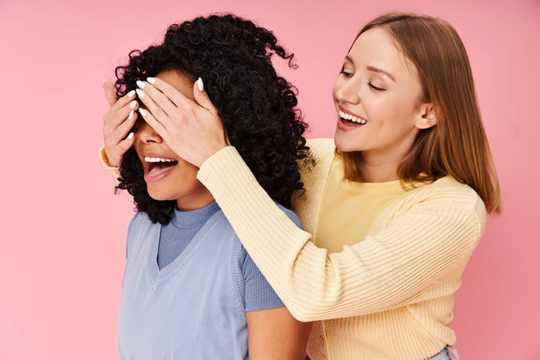 Zwei Frauen in lässiger Kleidung lachen und verbringen Zeit miteinander. - Foto, Bild