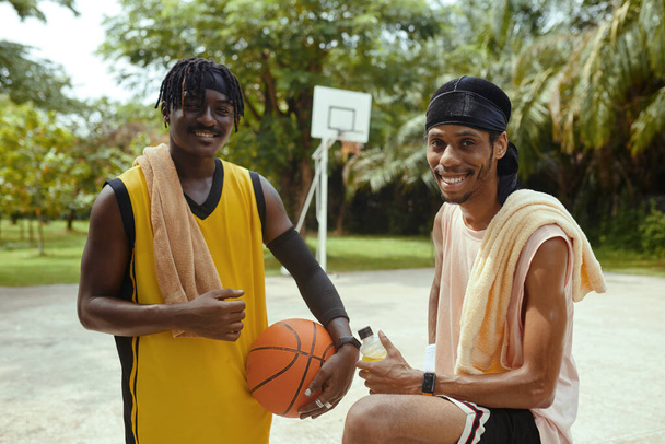 Portrait of cheerful Black streetball players sweaty after game - Photo, Image
