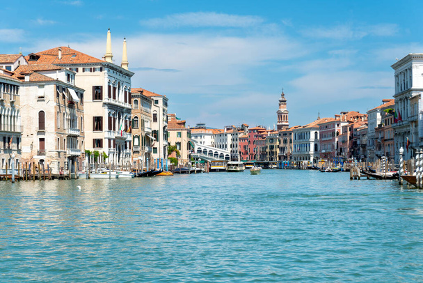 Benátky, Benátky - Itálie - 06-10-2021: Velký průplav pod modrou oblohou, lemovaný benátskou architekturou se známým mostem Rialto v pozadí - Fotografie, Obrázek