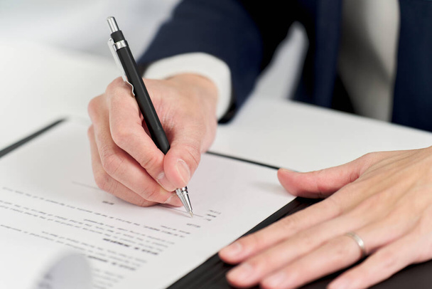 Hand van een zakenman die een contract ondertekent - Foto, afbeelding