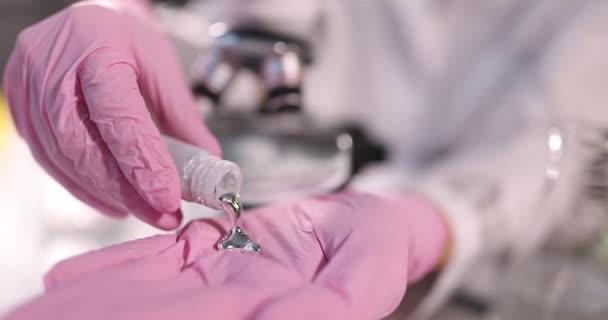 Scientist pours liquid mercury onto gloved hand. Liquid metal research in laboratory concept - Filmagem, Vídeo
