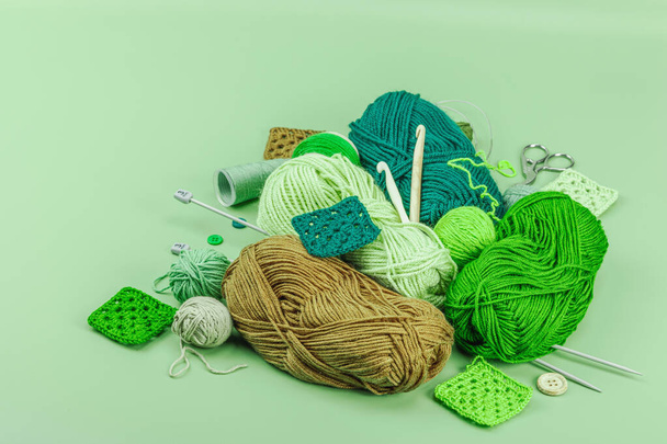 Um conjunto de fios de tricô e ferramentas em cores de primavera. Conceito feito à mão, arte criativa, processo de elaboração. Hobby, relax, lifestyle, flat lay on pastel green background, espaço de cópia - Foto, Imagem
