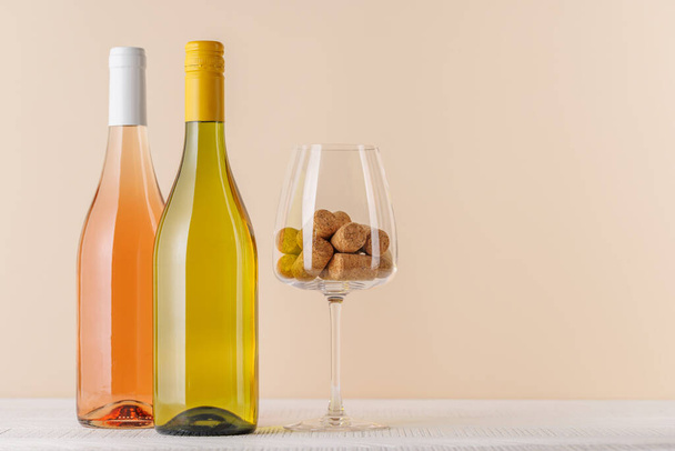 Rose και λευκό κρασί μπουκάλια στο τραπέζι με αντίγραφο χώρο - Φωτογραφία, εικόνα