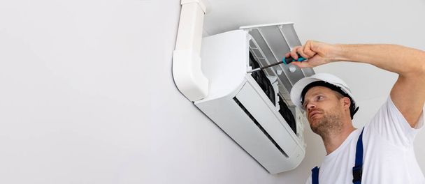 hvac services - technik instalujący klimatyzator na ścianie w domu. baner z przestrzenią do kopiowania - Zdjęcie, obraz