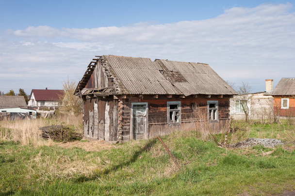 Casa de madera abandonada entre los árboles. Paisaje rural de primavera. - Foto, imagen