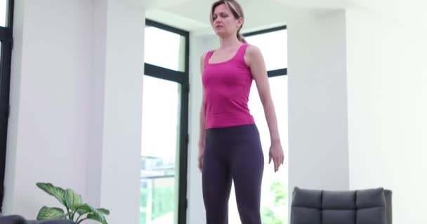 Mujer agarrando dolor de rodilla durante el entrenamiento deportivo en casa película 4k. Problemas de acondicionamiento físico en el hogar y dificultades - Imágenes, Vídeo