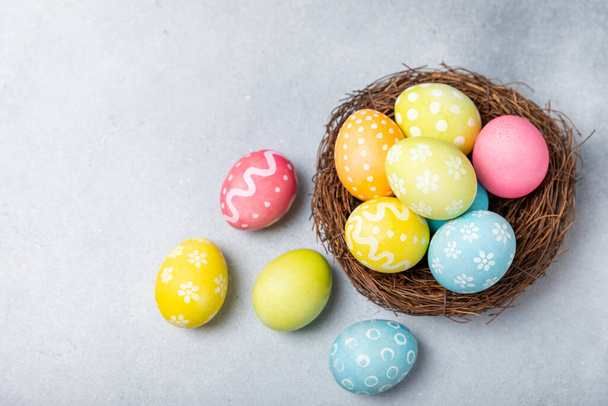 Húsvéti tojás a fészekben mimózavirágokkal fényes háttérrel. Húsvéti ünnepség koncepció. Színes húsvéti kézzel készített díszített húsvéti tojás. Helyet az sms-nek. Fénymásolási hely. - Fotó, kép
