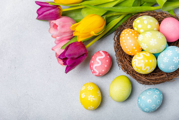 Húsvéti tojás a fészekben mimózavirágokkal fényes háttérrel. Húsvéti ünnepség koncepció. Színes húsvéti kézzel készített díszített húsvéti tojás. Helyet az sms-nek. Fénymásolási hely. - Fotó, kép