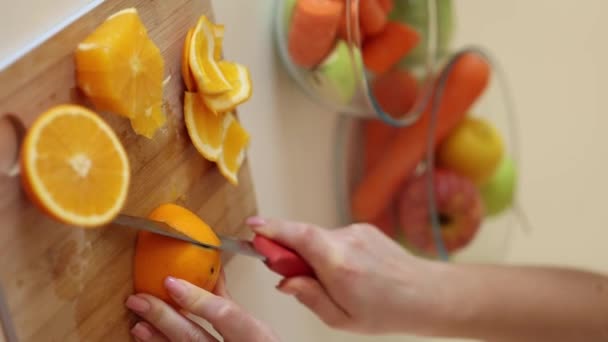 Arancione affettato su tavolo di legno. Le mani femminili tengono due pacchi di frutta. Foto di alta qualità - Filmati, video