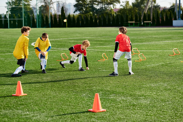 Μια ζωντανή ομάδα μικρών παιδιών που παίζουν με ενέργεια ένα παιχνίδι ποδοσφαίρου σε ένα χλοερό πεδίο, τρέξιμο, κλοτσιές, και επευφημίες καθώς ανταγωνίζονται σε ένα φιλικό αγώνα. - Φωτογραφία, εικόνα