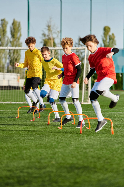 Група молодих хлопчиків грає в енергійну гру в футбол на трав'янистому полі. Вони бігають, штовхають м'яч, і радіють один одному, коли вони змагаються. - Фото, зображення